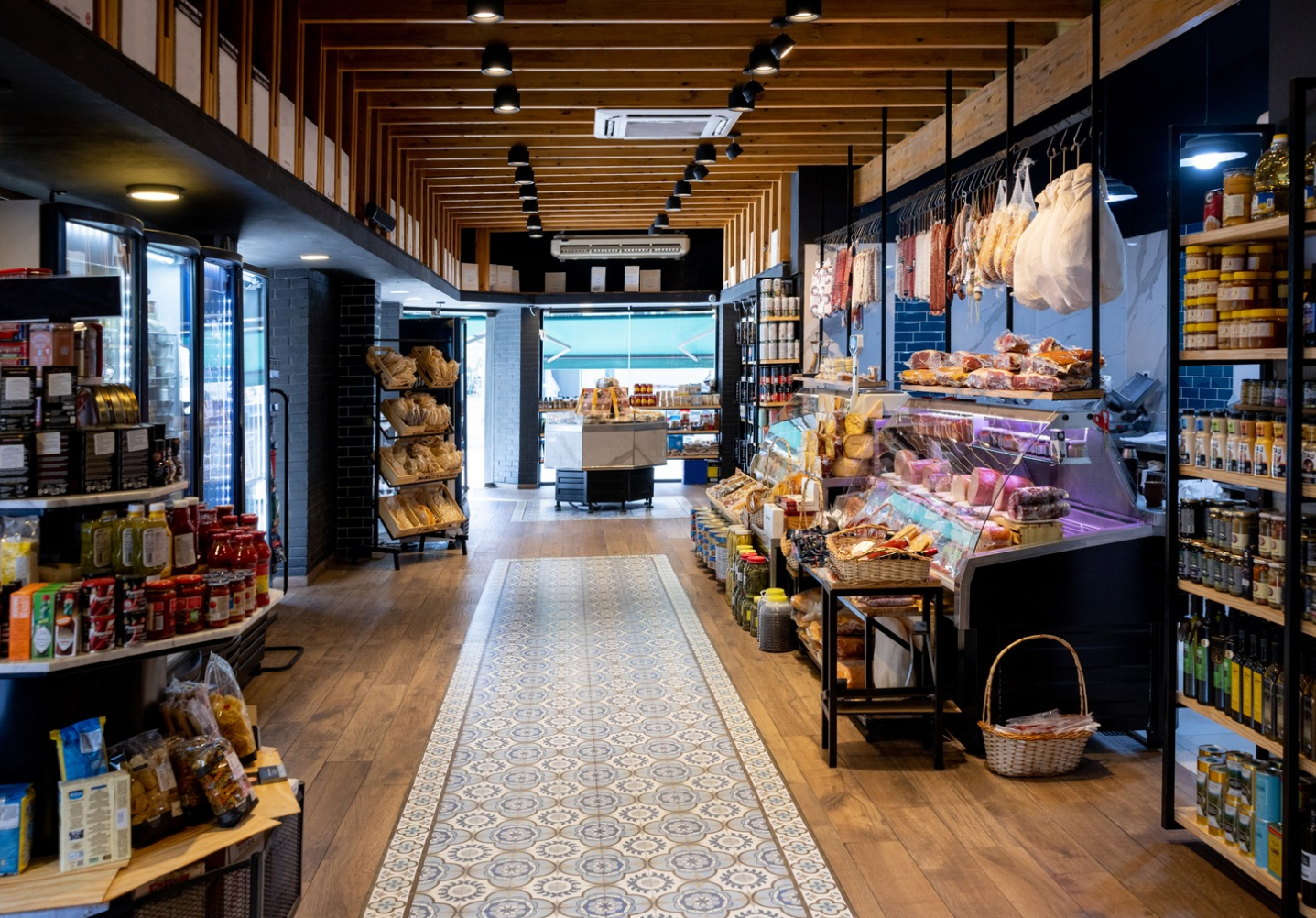 Interior of a specialty market at Rivulet with fresh goods, deli counter, and wood-lined ceiling